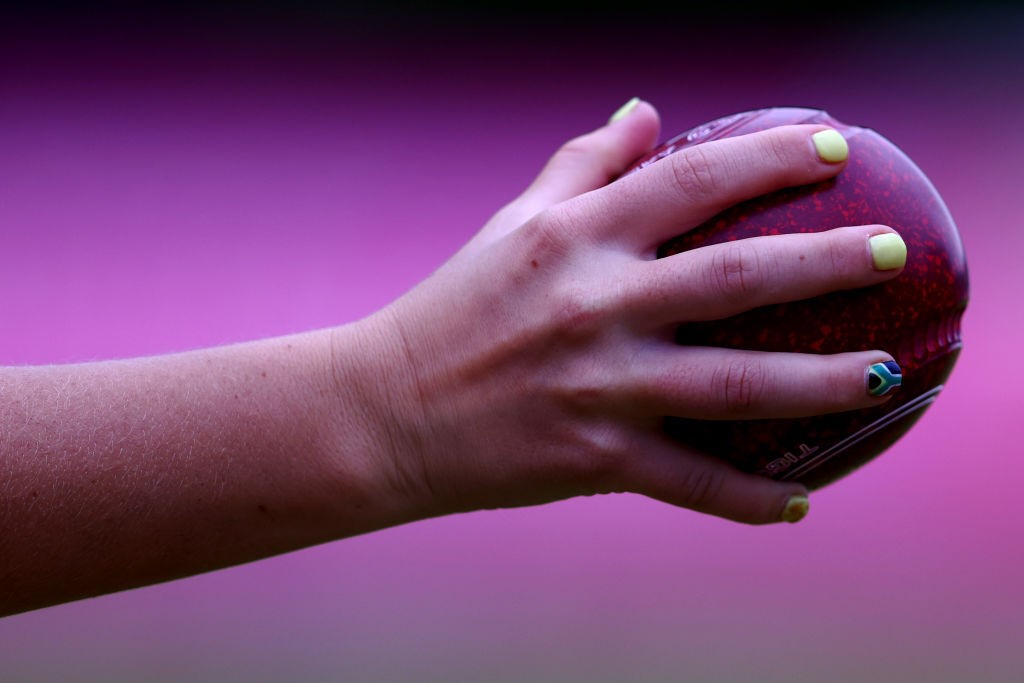 a woman's hand holds a ball showing a manicure with the south african flag