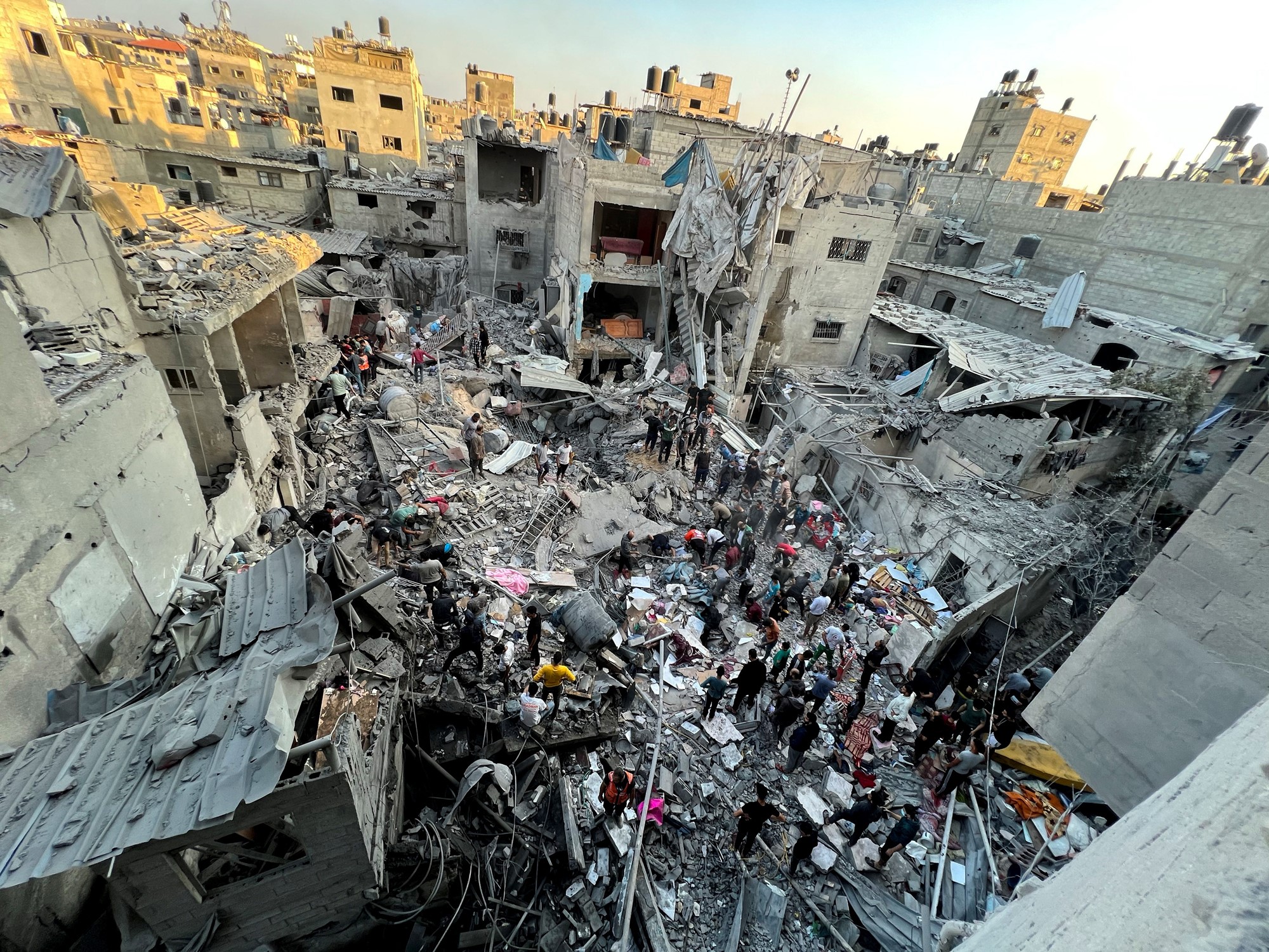 Aerial view of a destroyed buildings and people walking among the debris