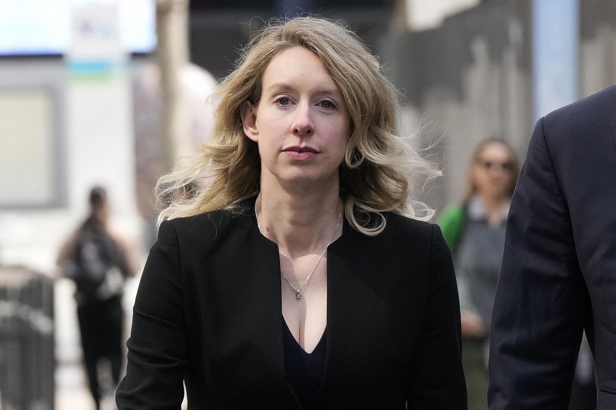 Elizabeth Holmes walks down a street.