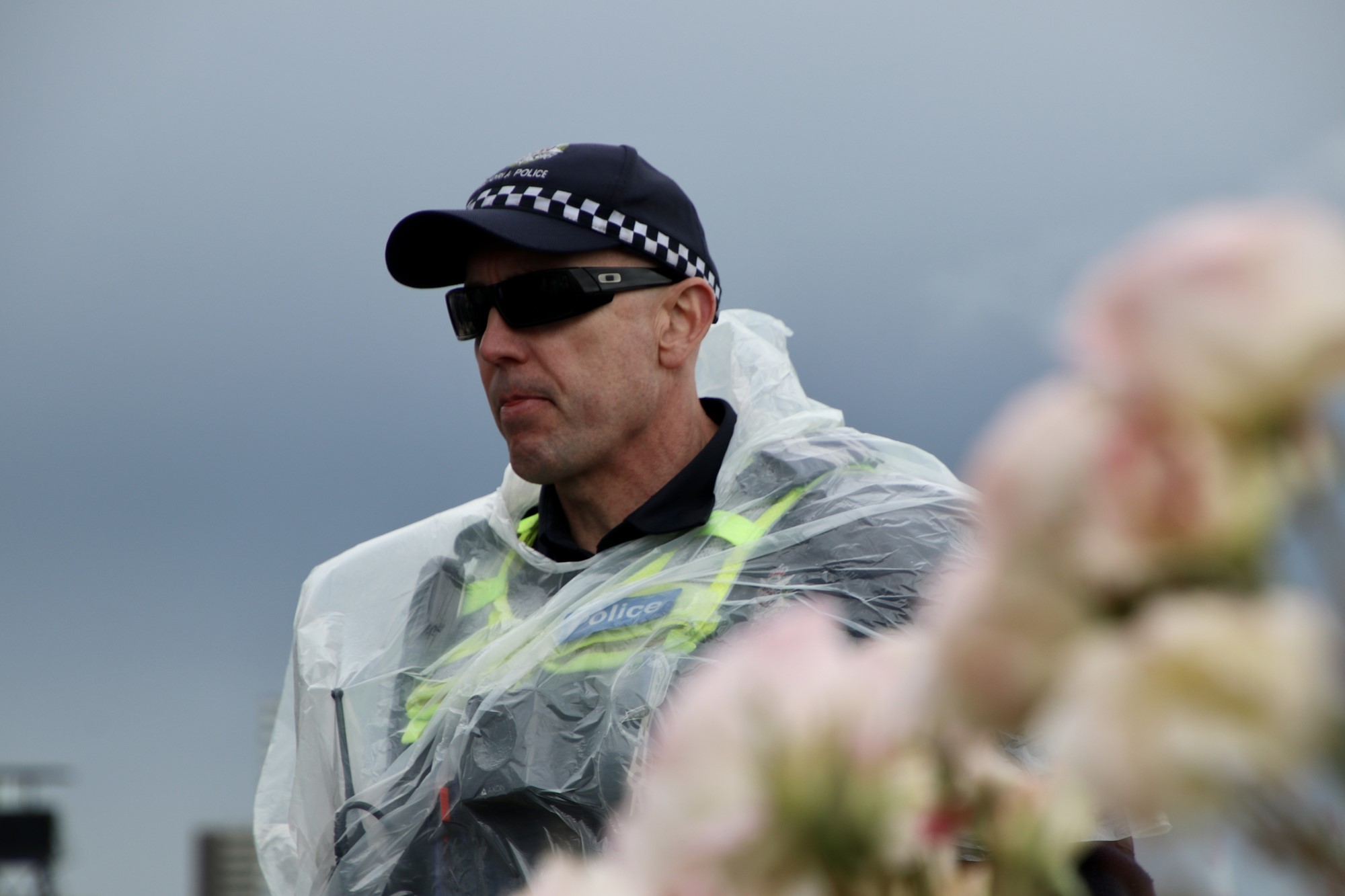 Police officer stands in a rain poncho.