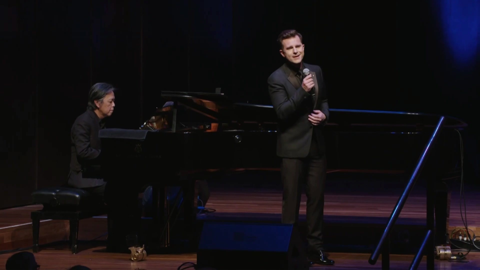 David Campbell sings beside a piano.