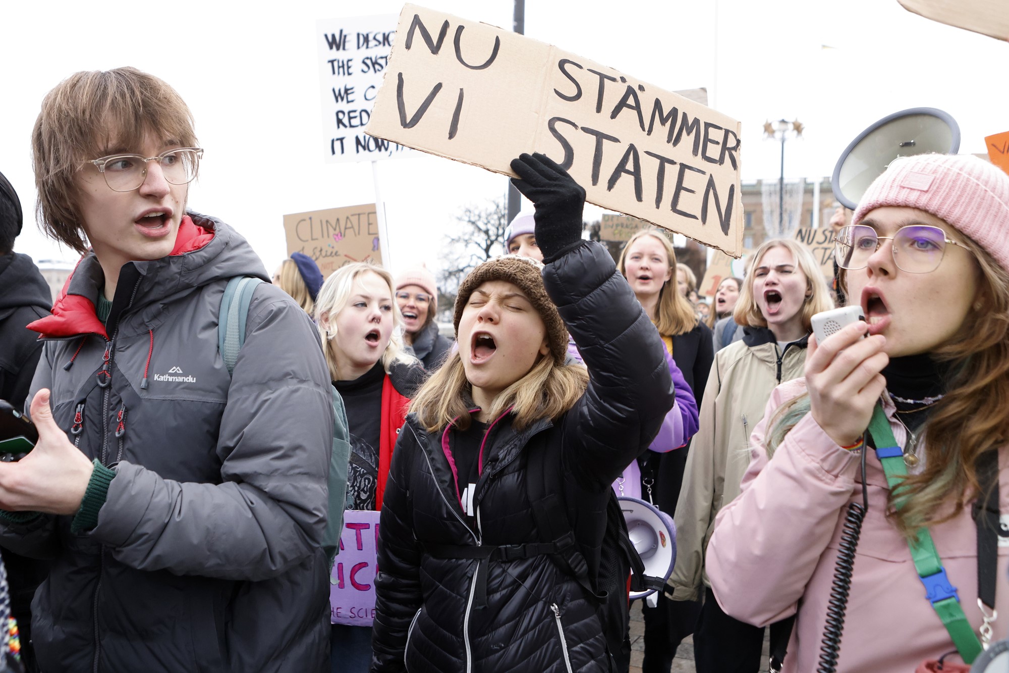 Greta Thunberg  holding a protest sign. 