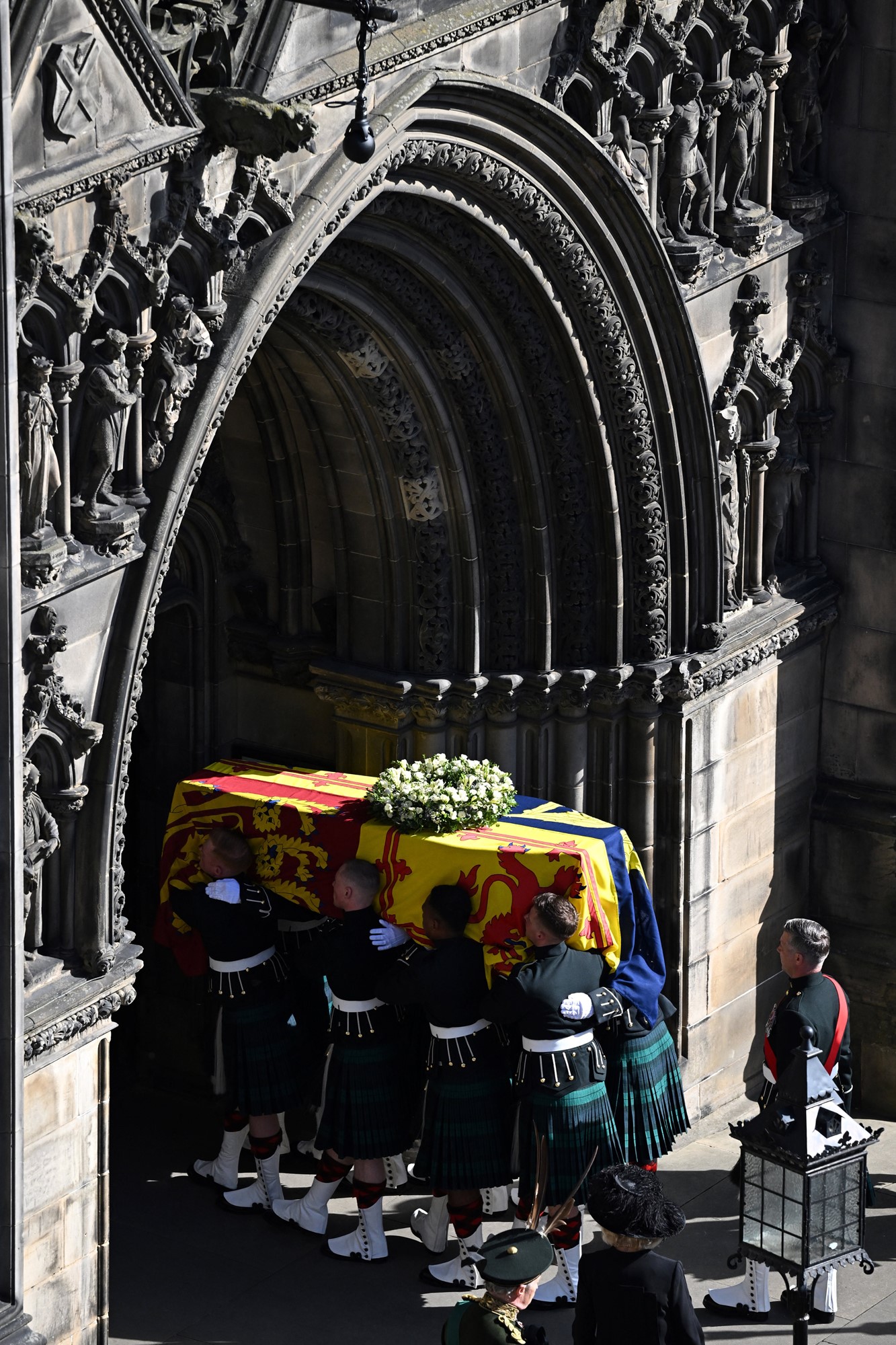 Pallbearers carry the coffin of Queen Elizabeth II, draped in the Royal Standard of Scotland, into St Giles' Cathedral, in Edinburgh, on September 12, 2022