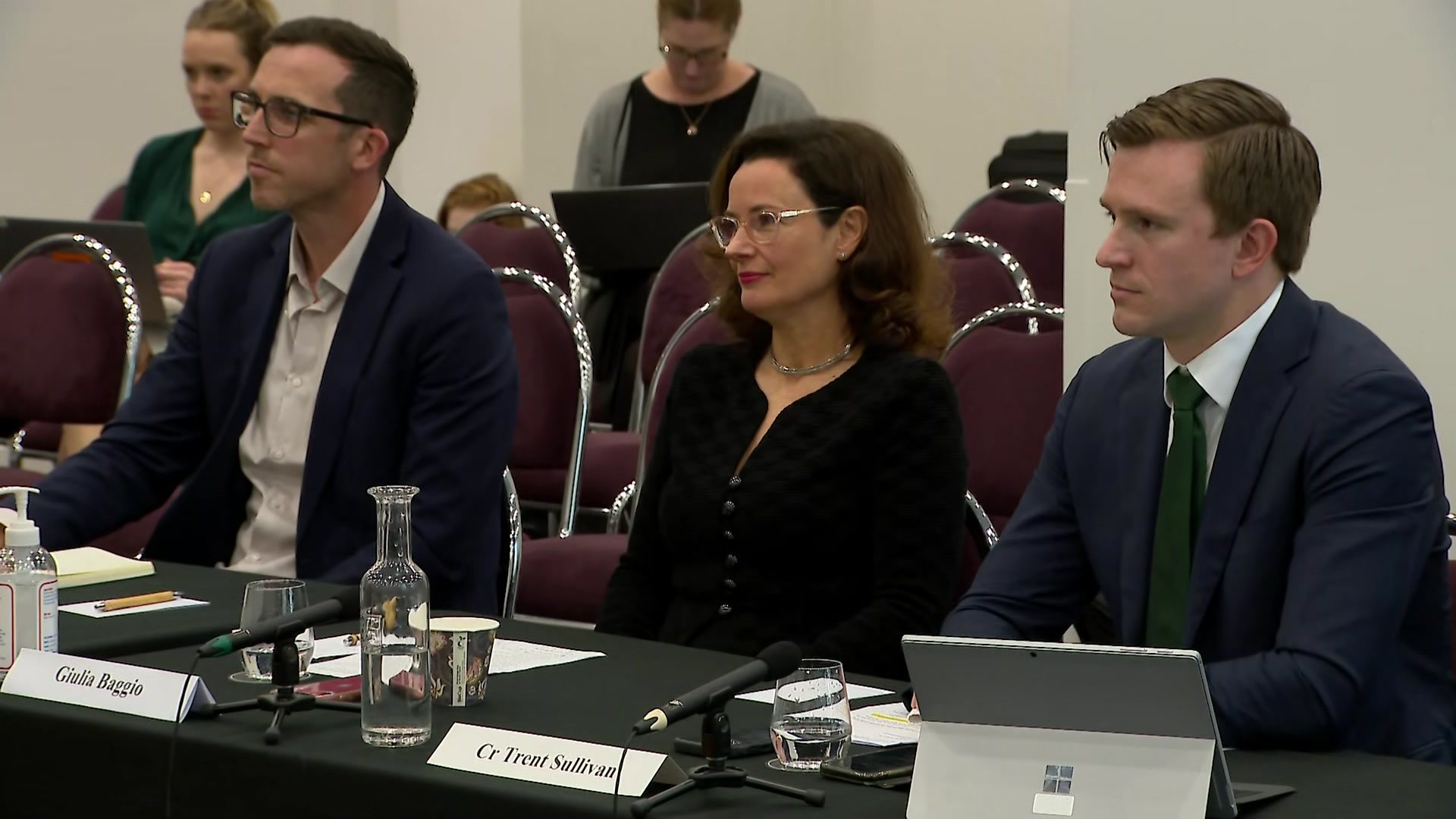 Trent Sullivan and Gilia Baggio sit at an inquiry hearing.