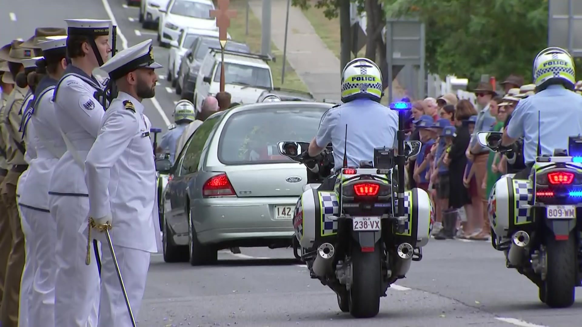 Bill Hayden's coffin leaves the church in a herse with flowers.