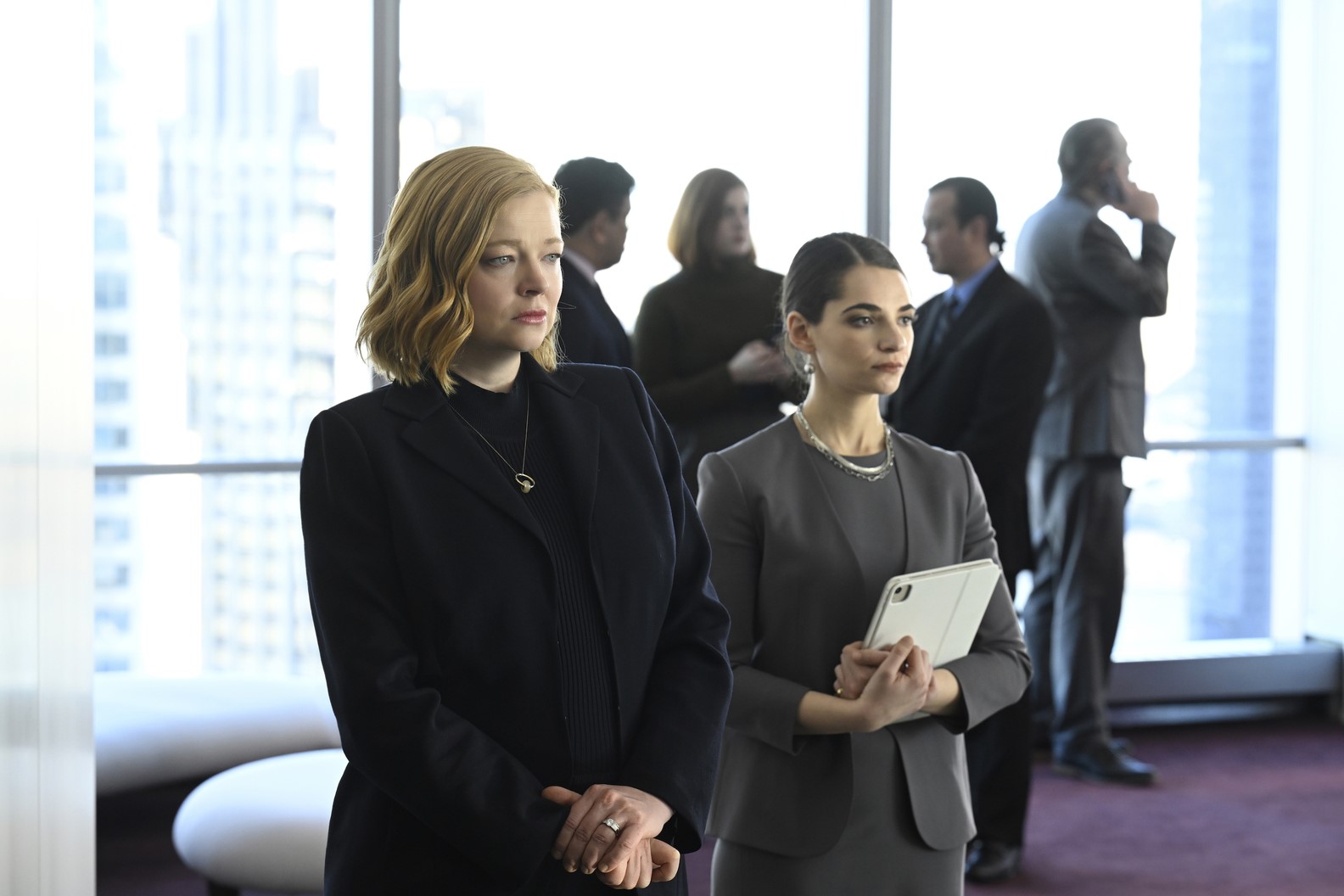Shiv stands in a boardroom with her assistant.
