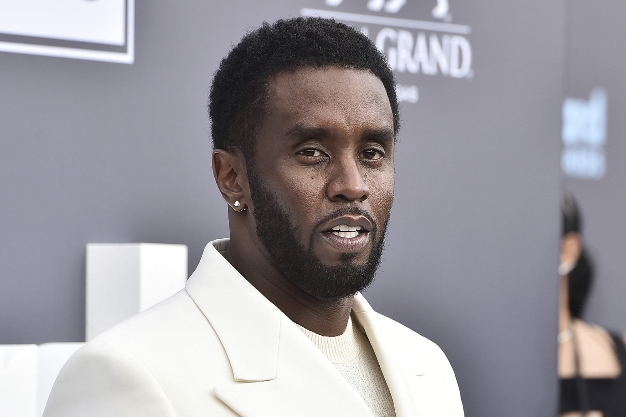 A black man in a suit stands for photos during a media event