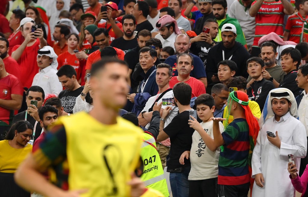 Qatar World Cup fans watch Cristiano Ronaldo warm up on the sidelines of Portugal's match against Switzerland.