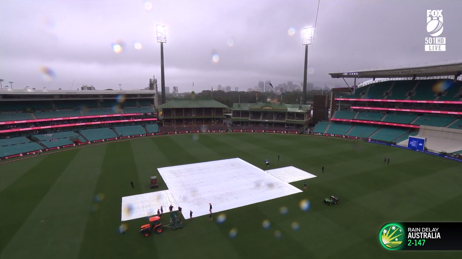 Rain on the camera lens in this screenshot from Fox Sports showing covers on the pitch at the SCG during a cricket Test.
