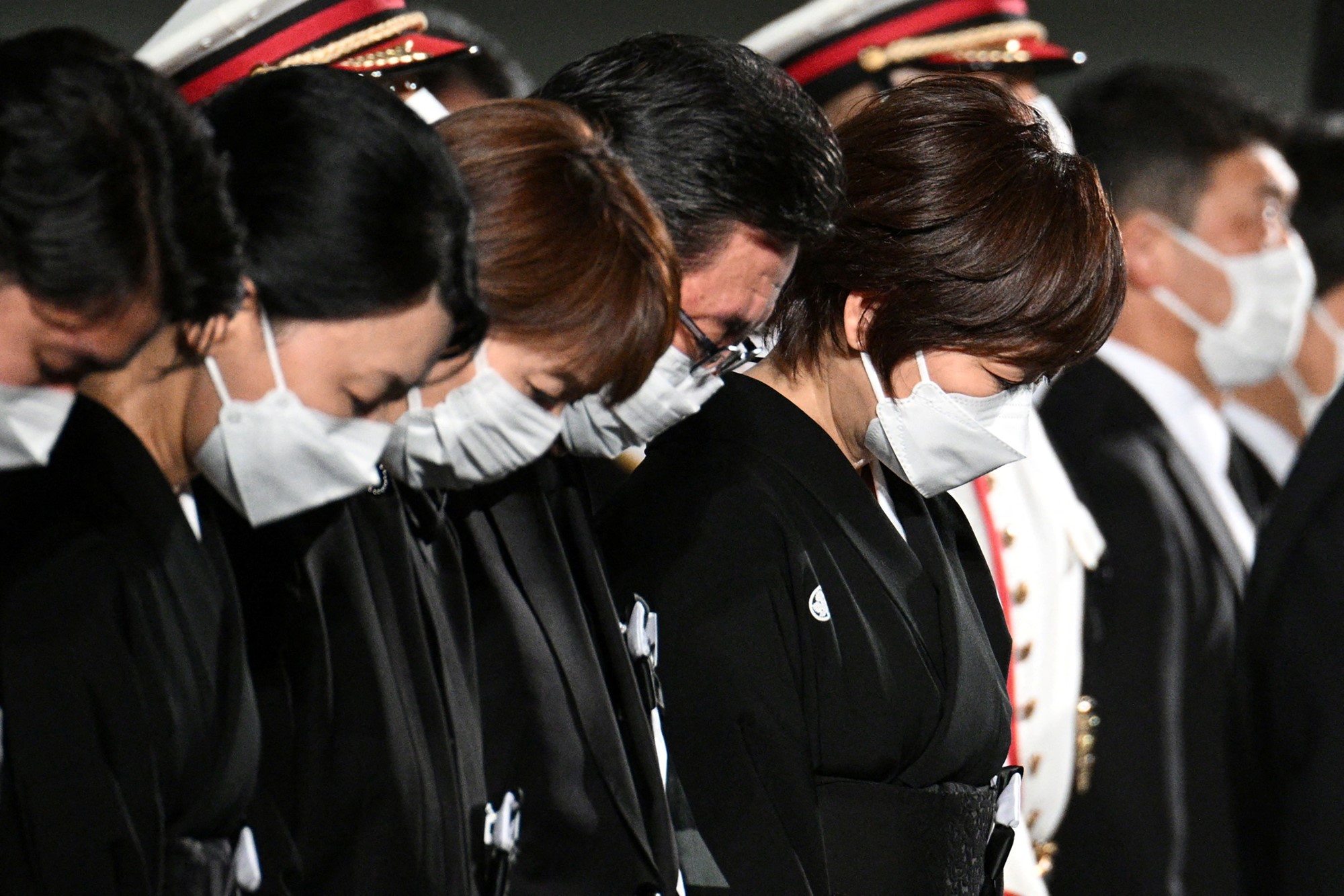 The widow of former Japanese prime minister Shinzo Abe, Akie Abe (R), bows her head