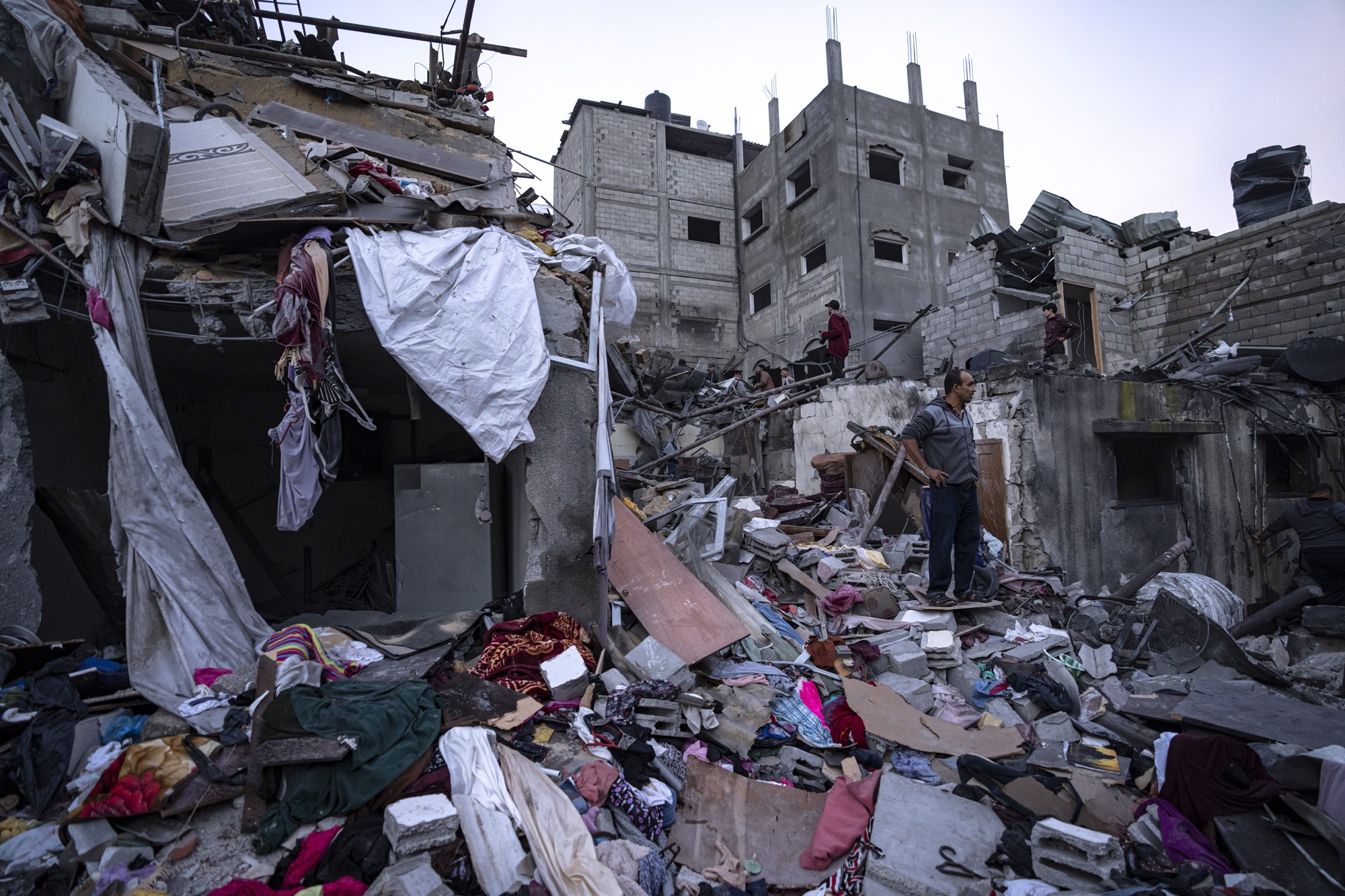 Destroyed buildings with clothing and debris across the ground. 