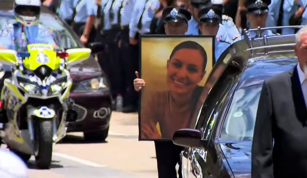 An officer carries a large framed photo of Rachel.