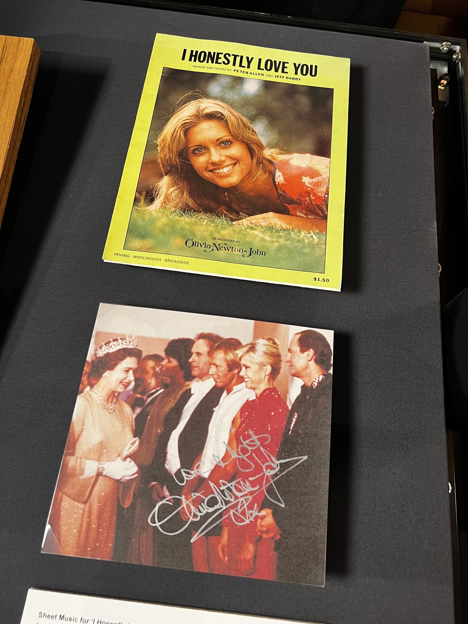 Olivia Newton-John stands in a row of performers in front of the Queen.