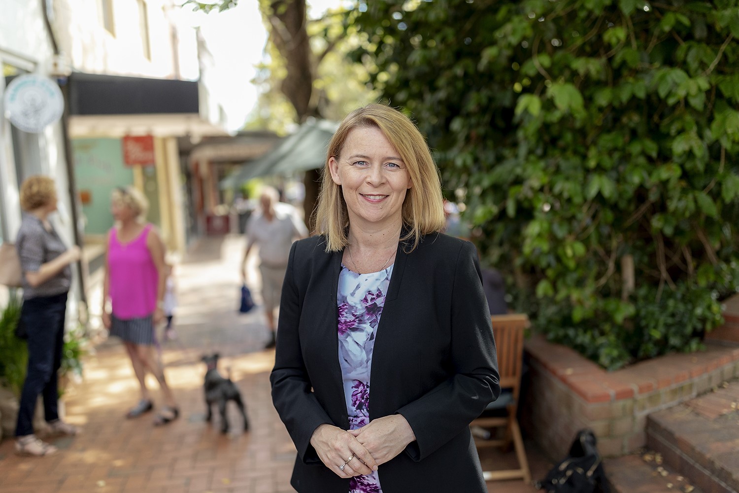 Woman in blazer stands outside