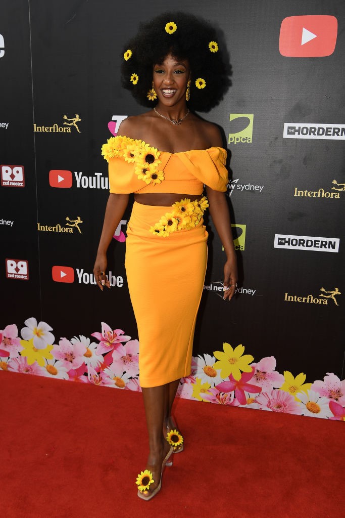 Tsehay Hawkins hits the red carpet in a yellow dress and sunflower-embellished hair accessories
