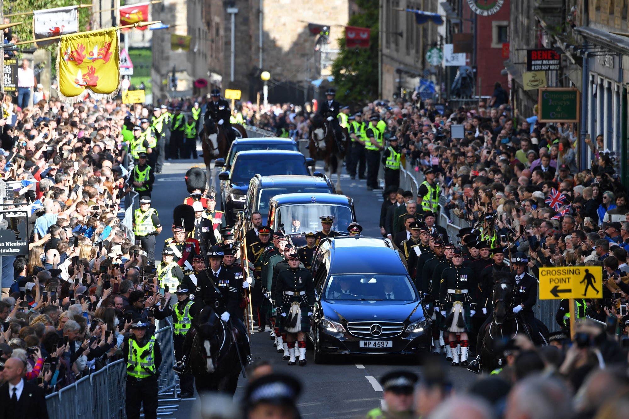 Members of the public gather to watch the procession of Queen Elizabeth II's coffin, from the Palace of Holyroodhouse to St Giles Cathedral, on the Royal Mile on September 12, 2022