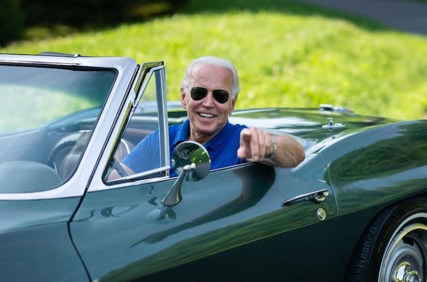 Joe Biden smiling sitting in his green corvette.
