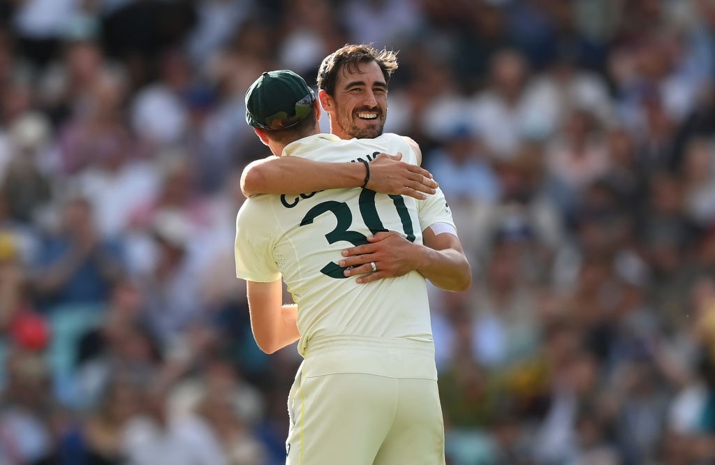 Australia bowlers Mitchell Starc and Pat Cummins hug during an Ashes Test.