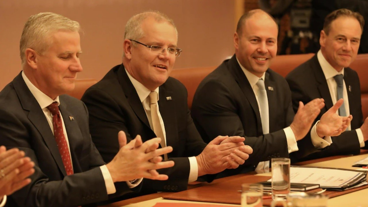 Scott Morrison and a group of government ministers clapping.