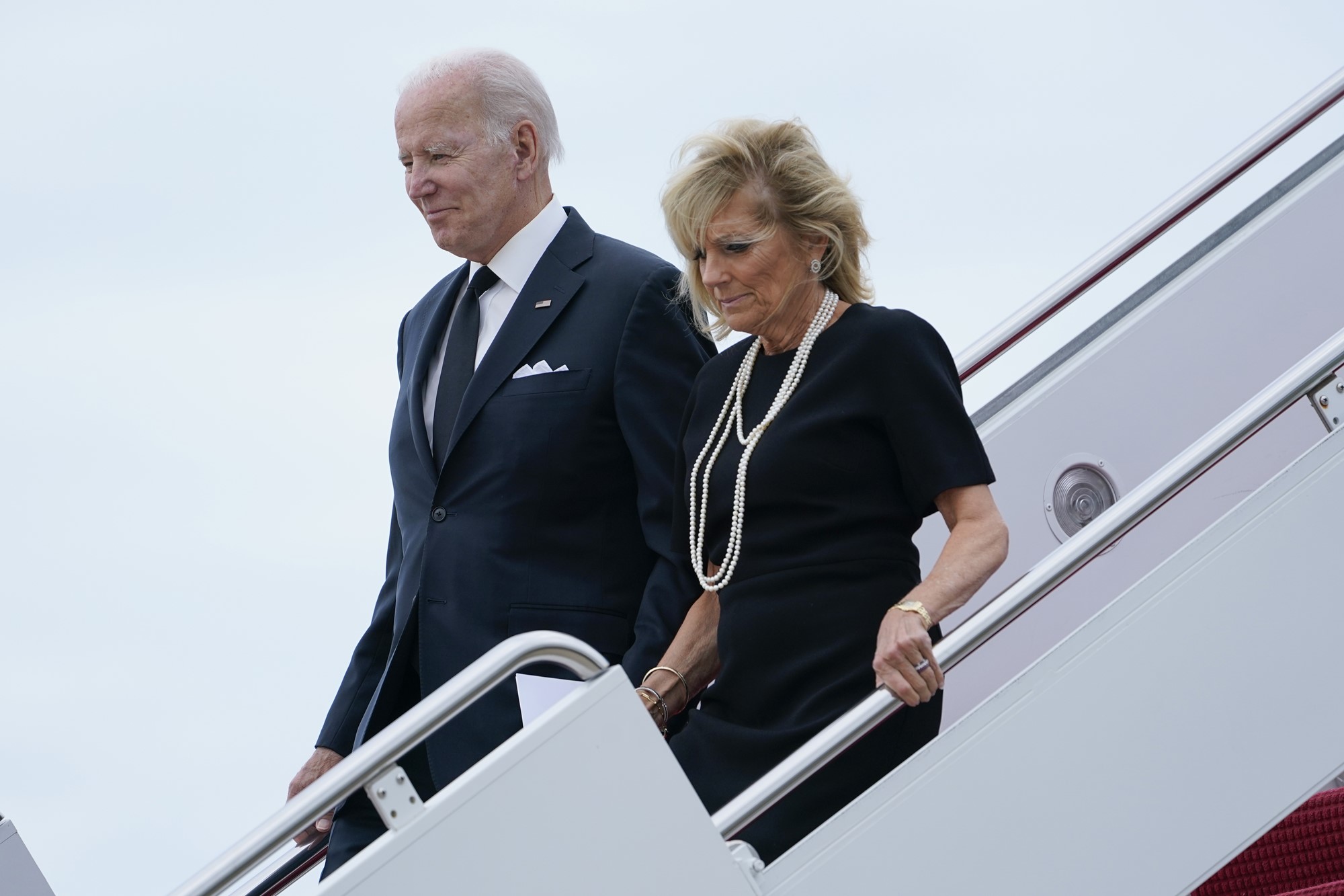 Joe Biden and Jill Biden walk down aircraft stairs