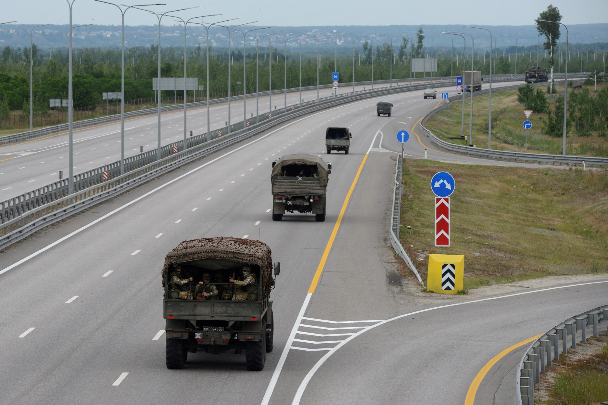 Military vehicles are pictured driving down the highway.