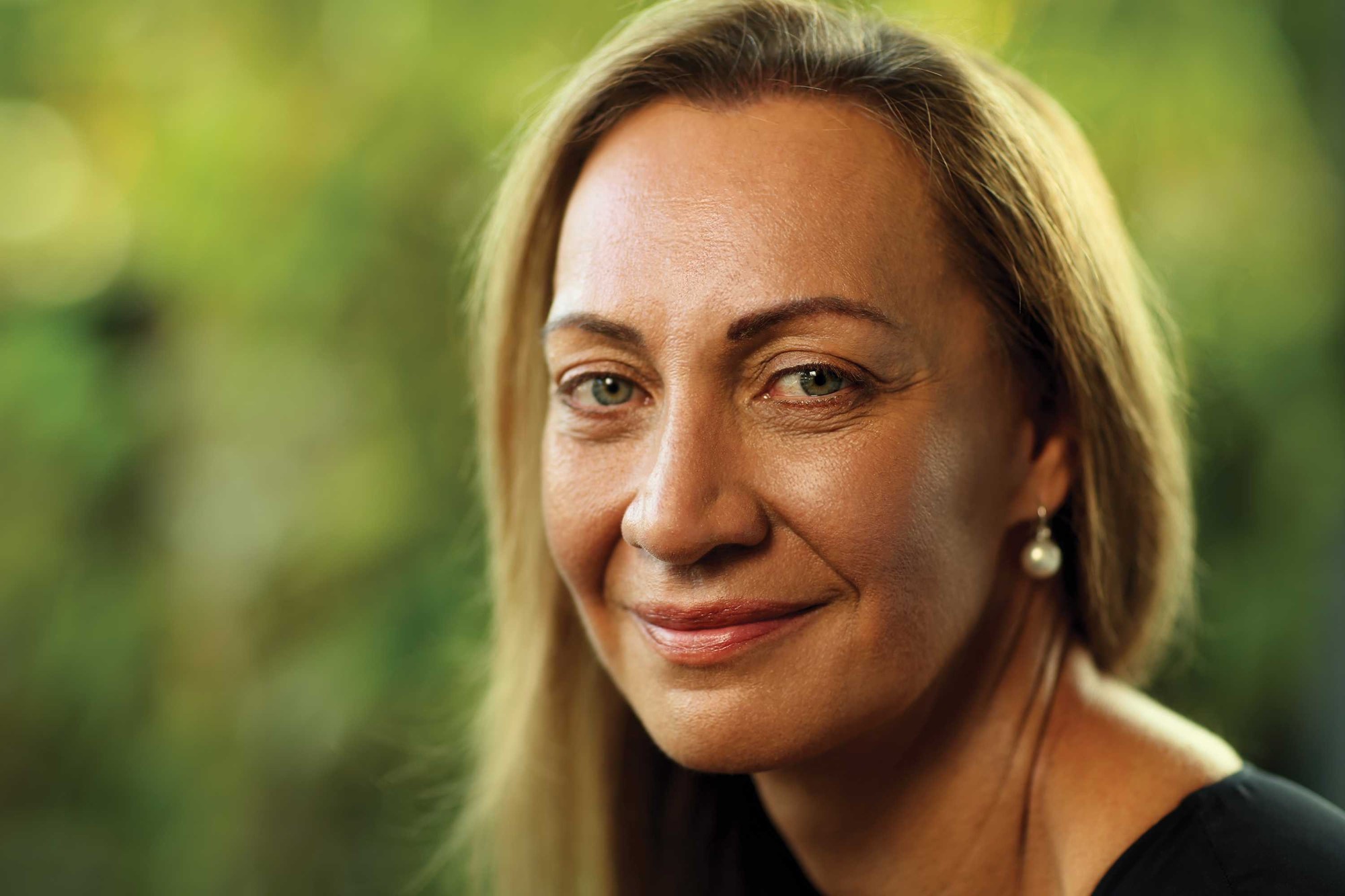 A portrait of Tracy Westerman with a green background.