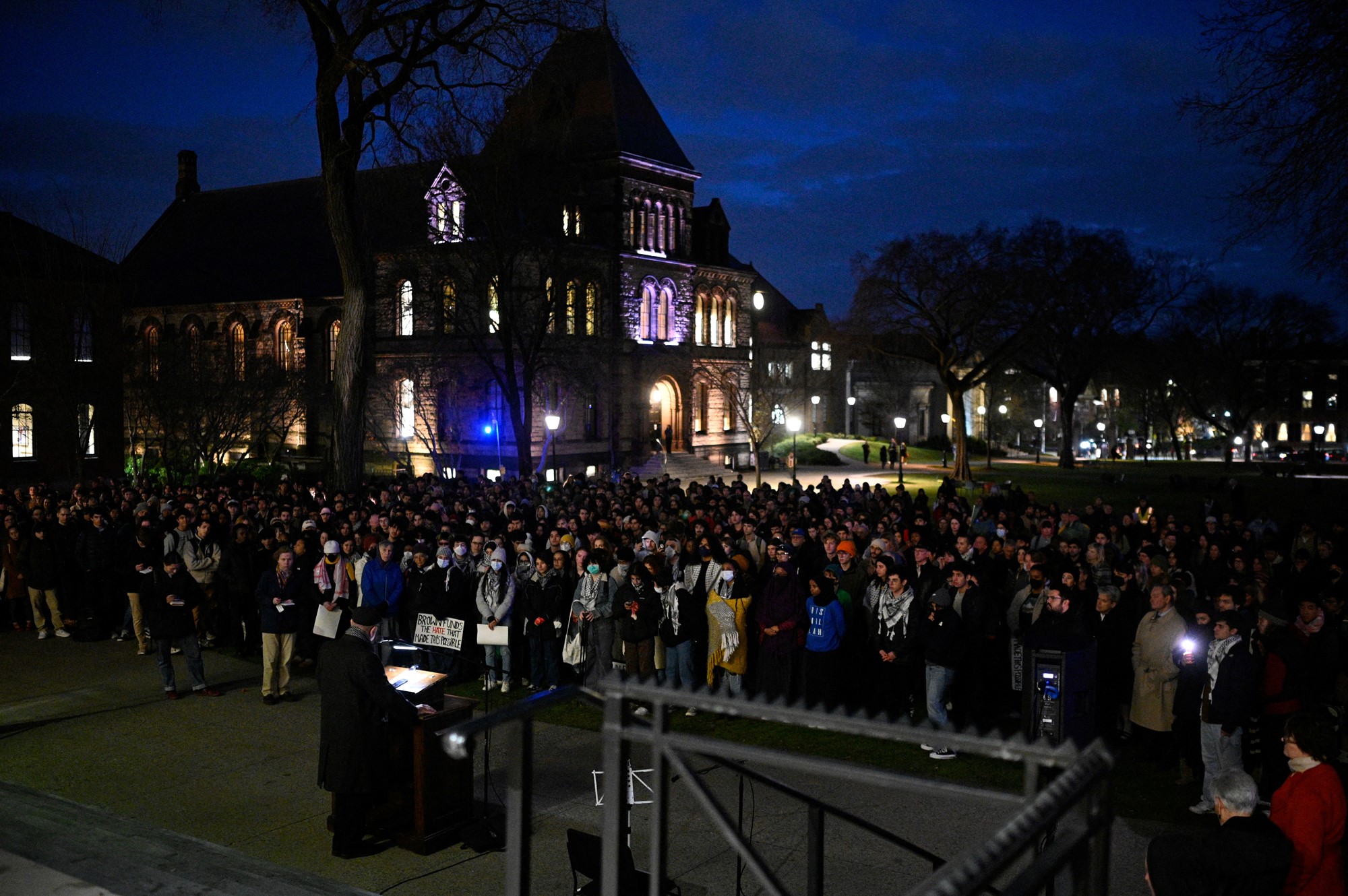 A group of students in the dark holding candles