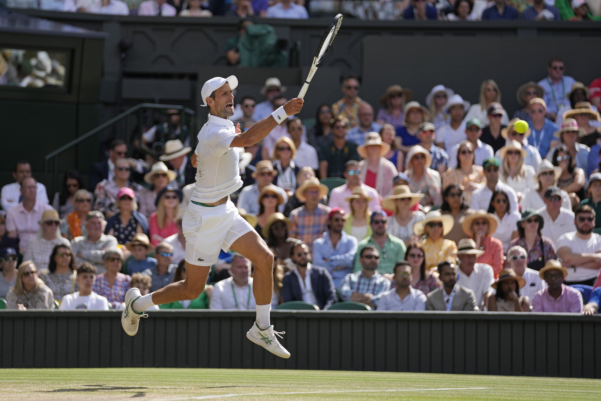 Novak Djokovic is off the ground as he hits a forehand in the Wimbledon final.