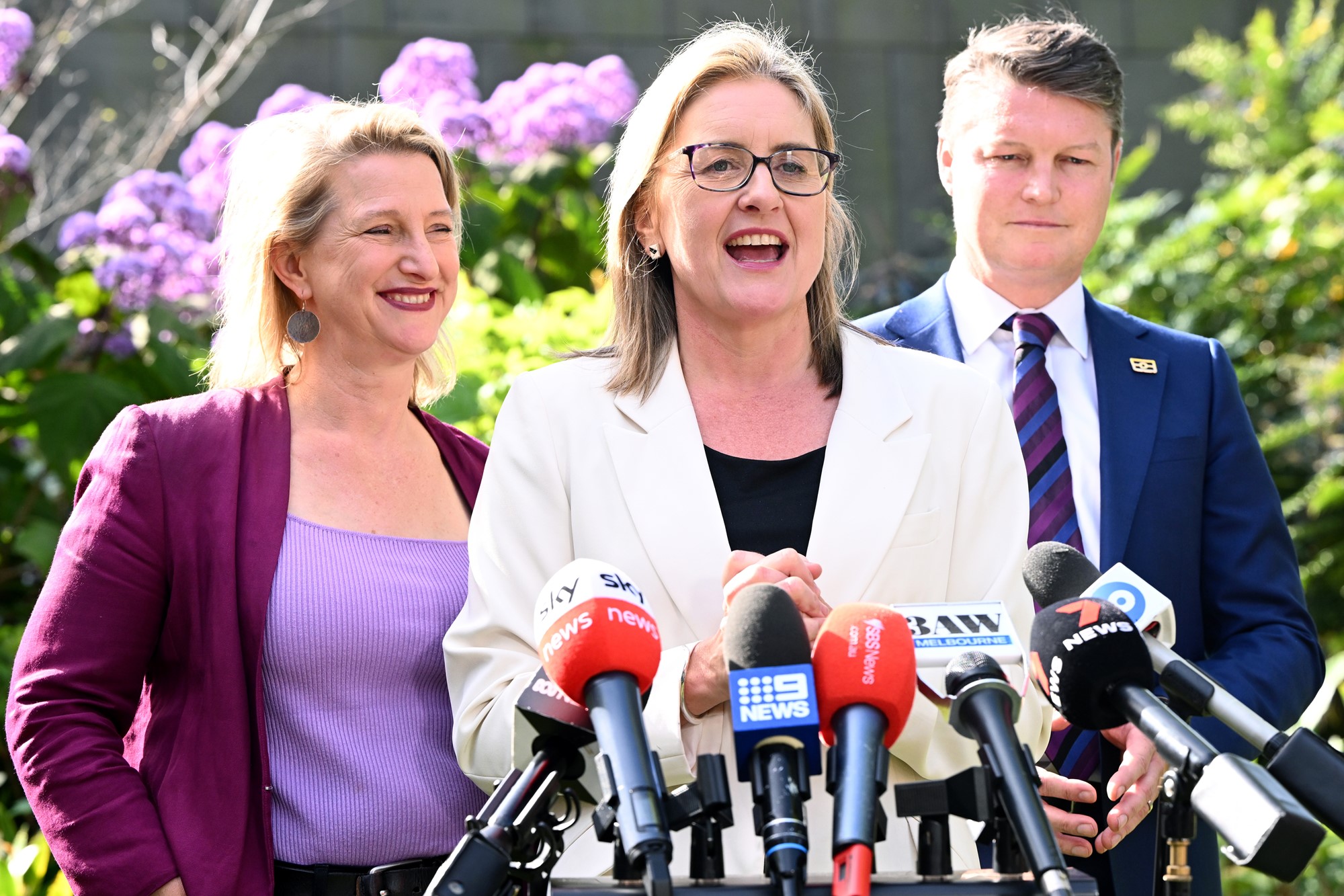 Jacinta Allan addresses the media in a sunlit garden.