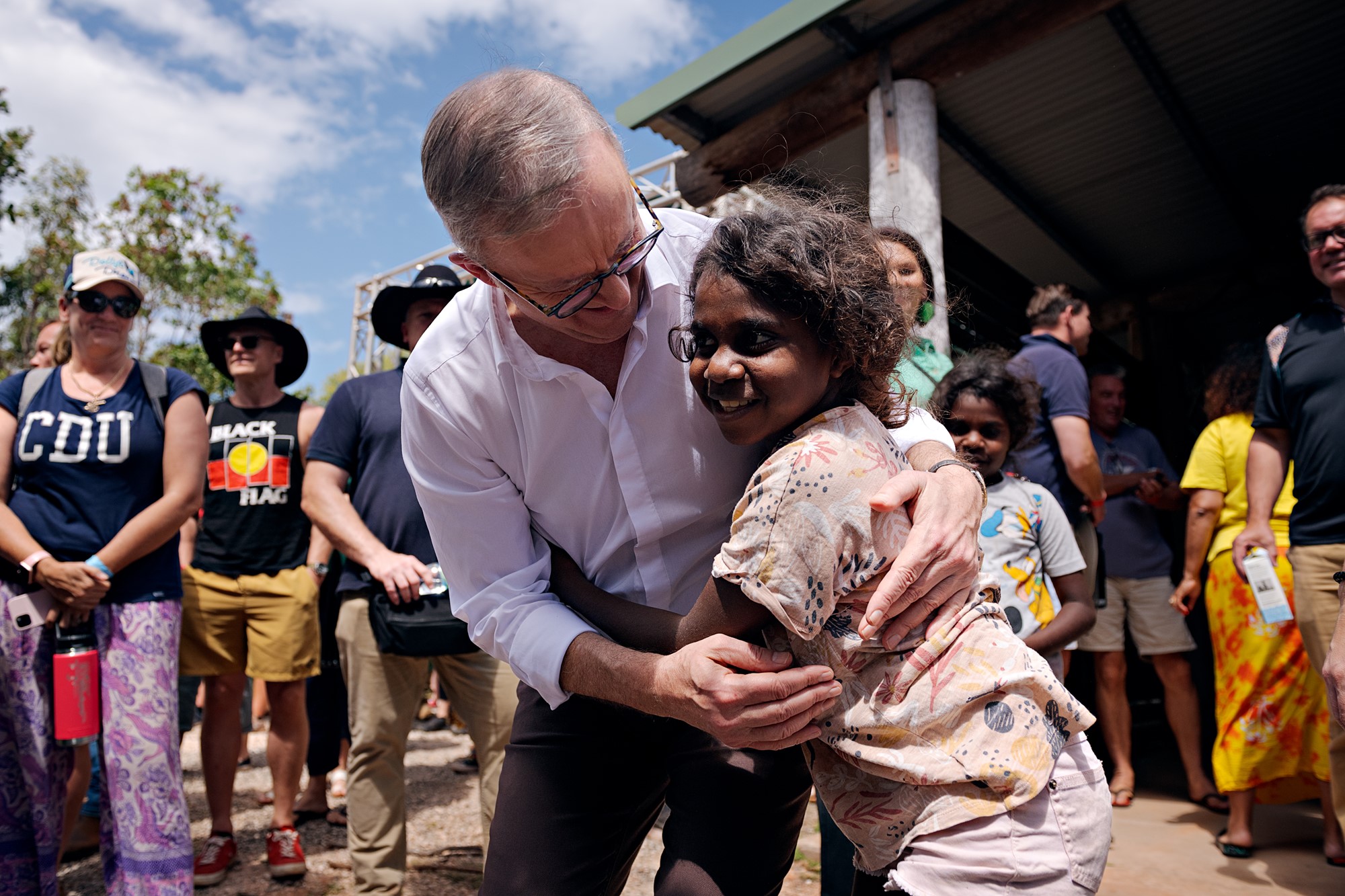 Albanese is hugged by an indigenous girl outside the covered forum.