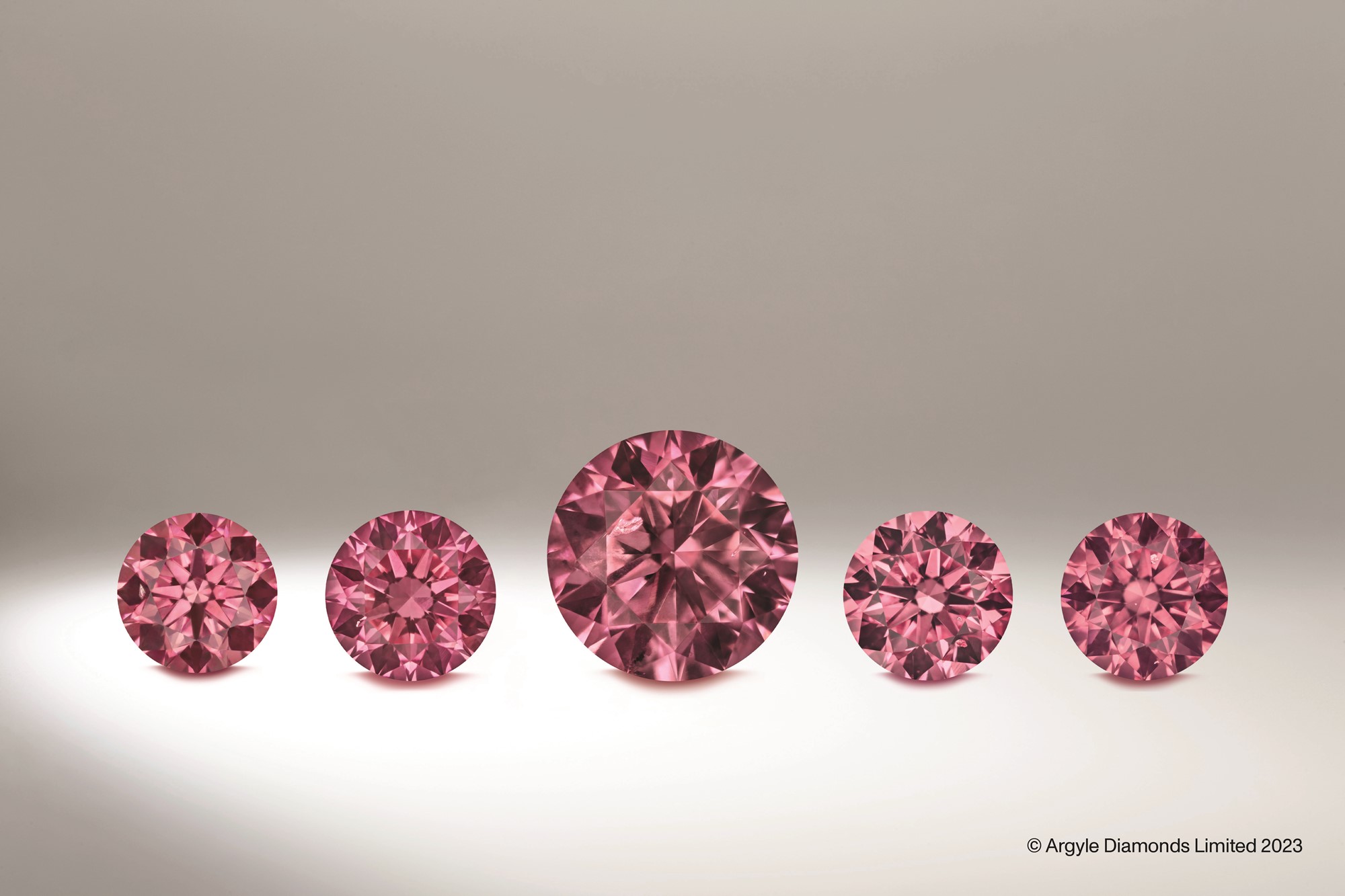 Five round pink diamonds in a row, the middle one is the biggest.