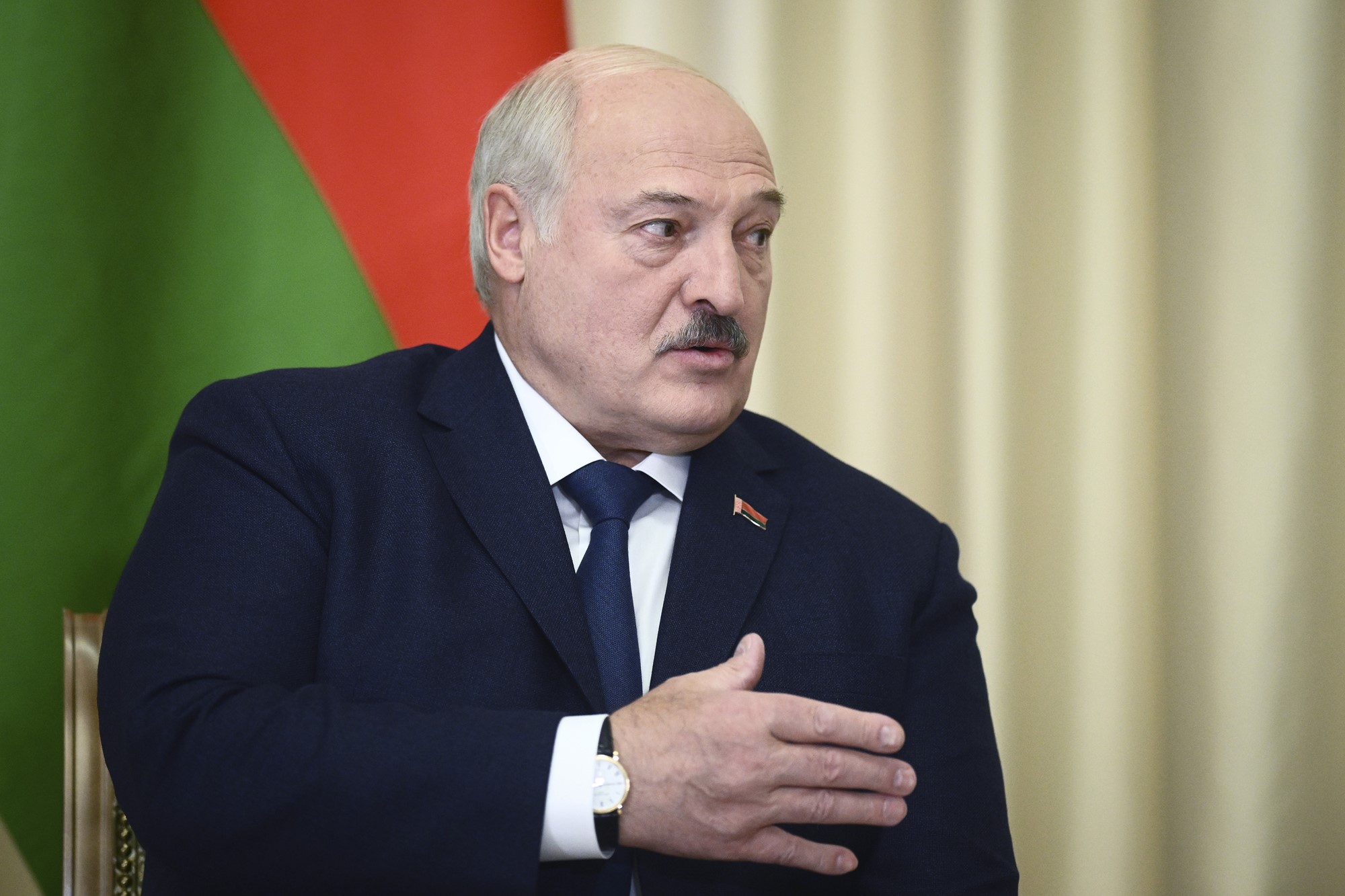 Alexander Lukashenko speaks with his hand on his chest. 