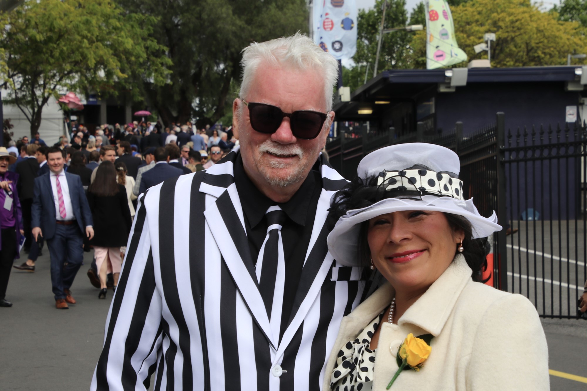 Mark and Carmen Dean smile, dressed in black and white.