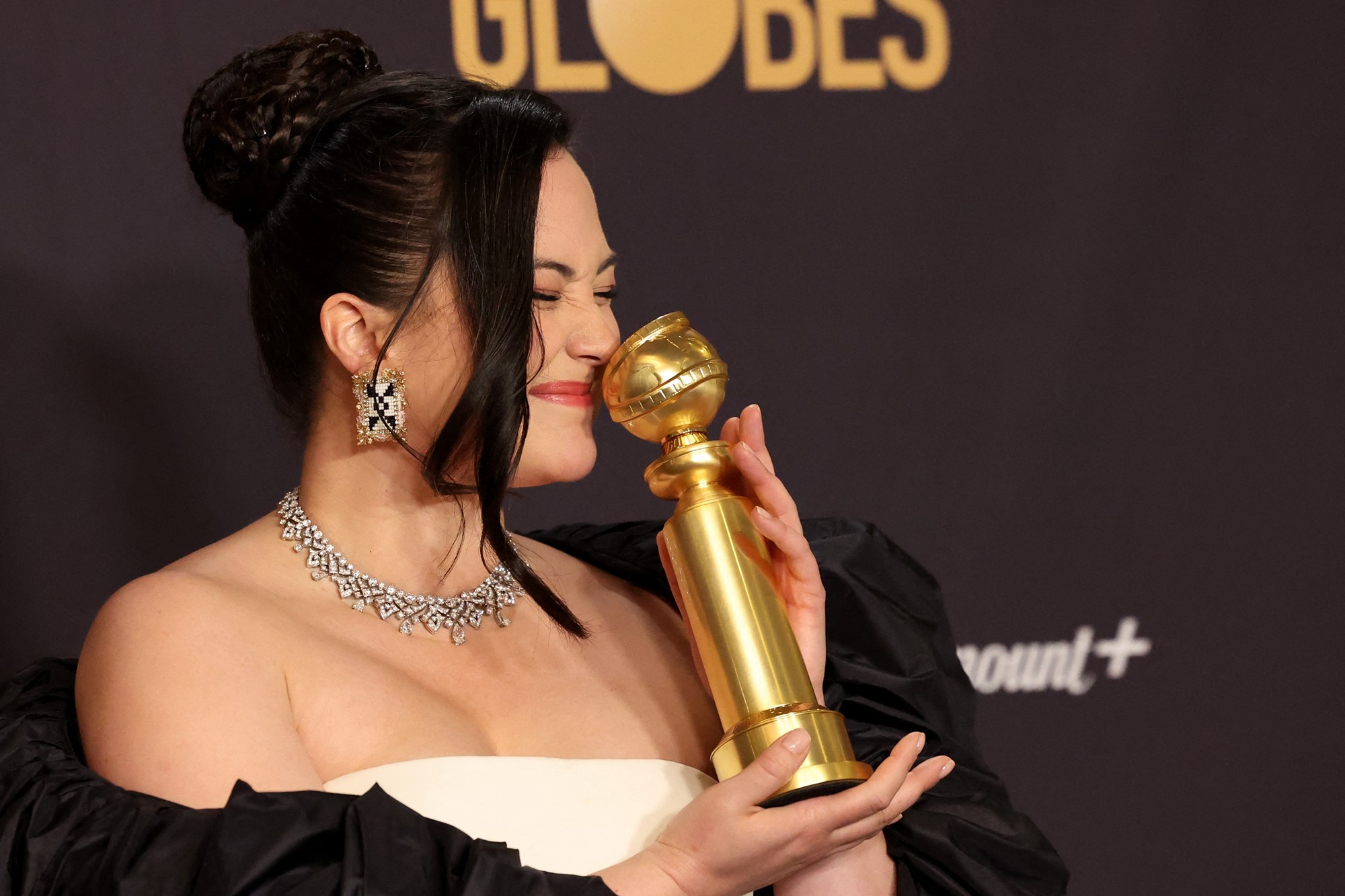 A woman kisses a Golden Globes.