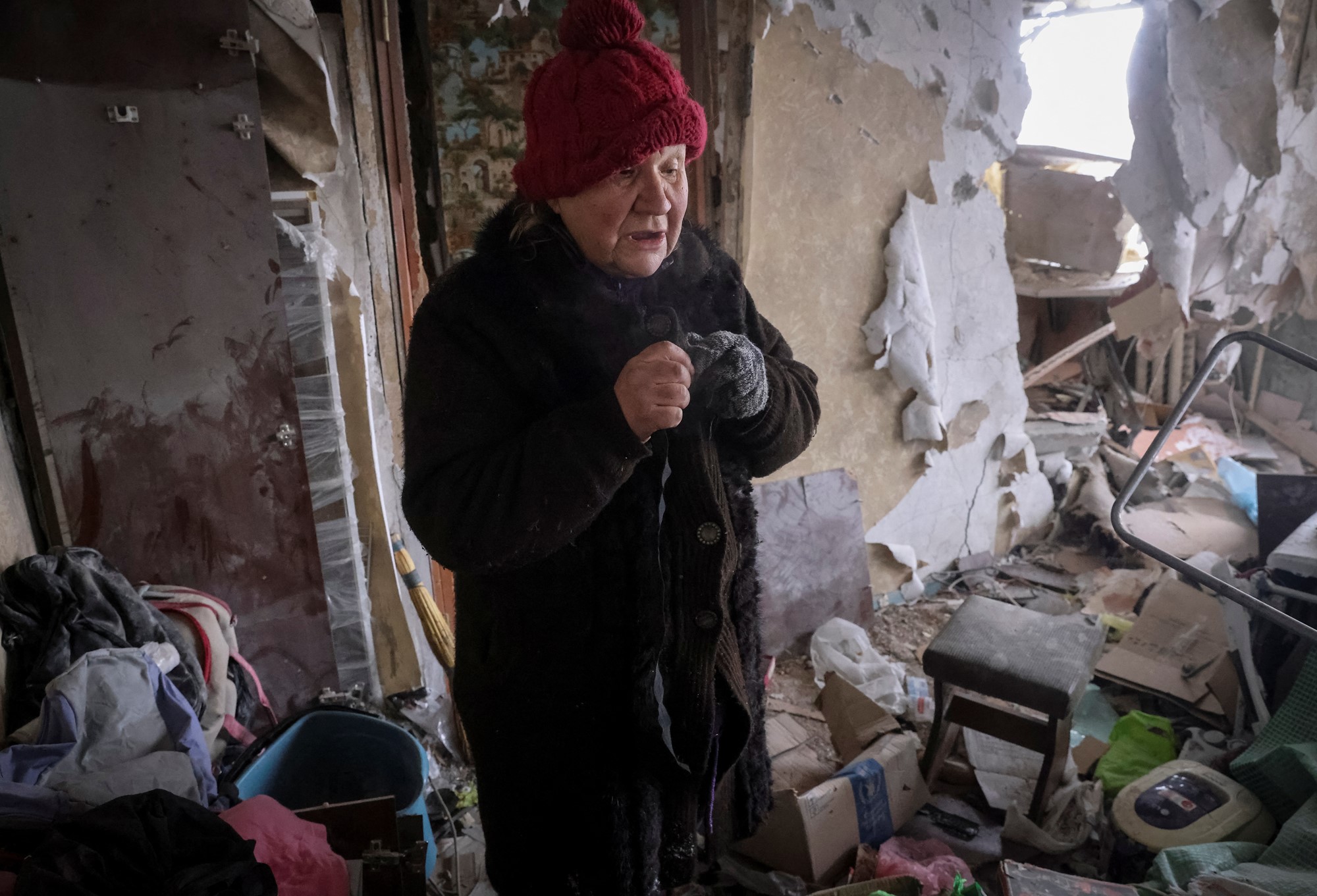 A local resident stands in her house, which was damaged by a Russian military strike, in the front line city of Vuhledar.