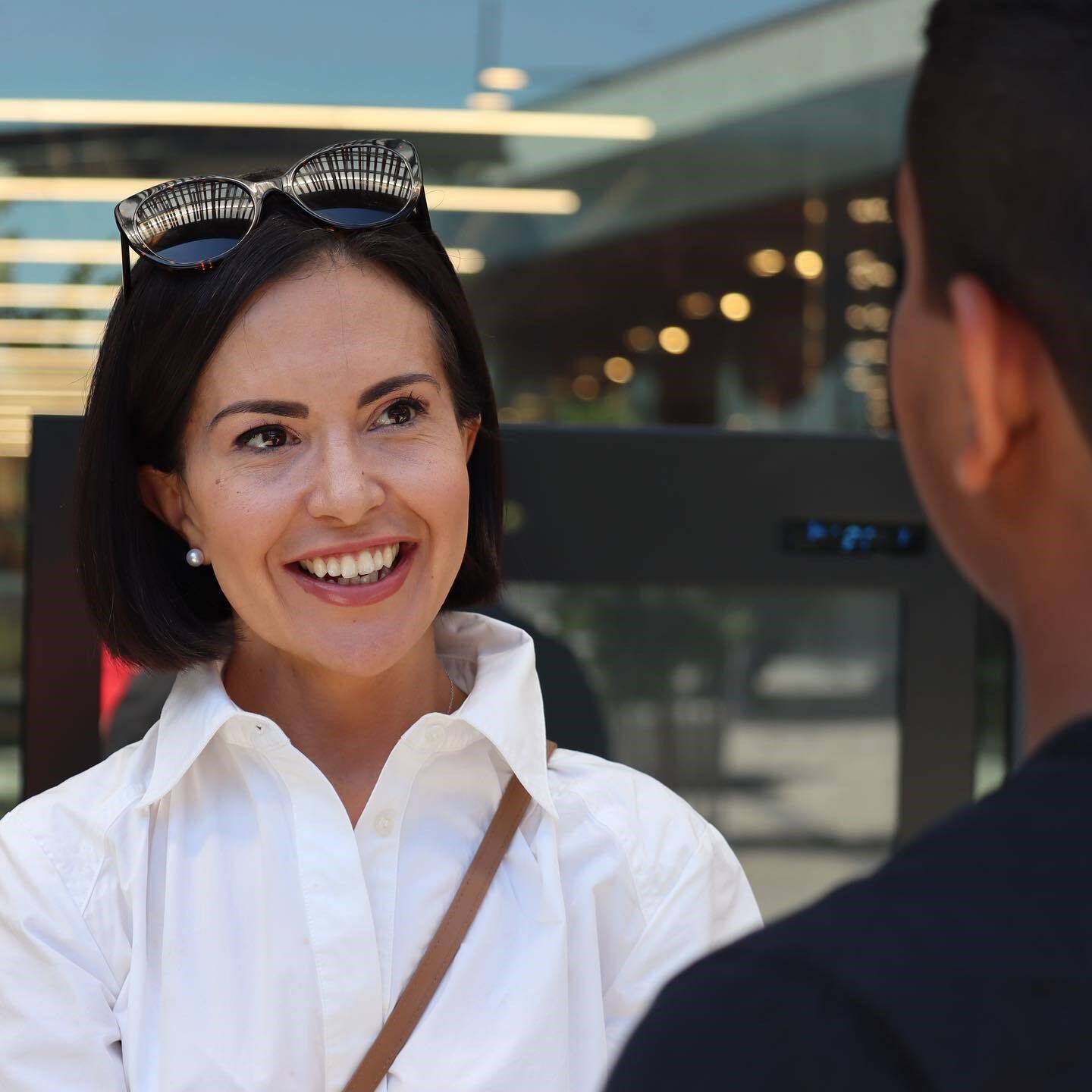 Woman in white shirt smiles while talking