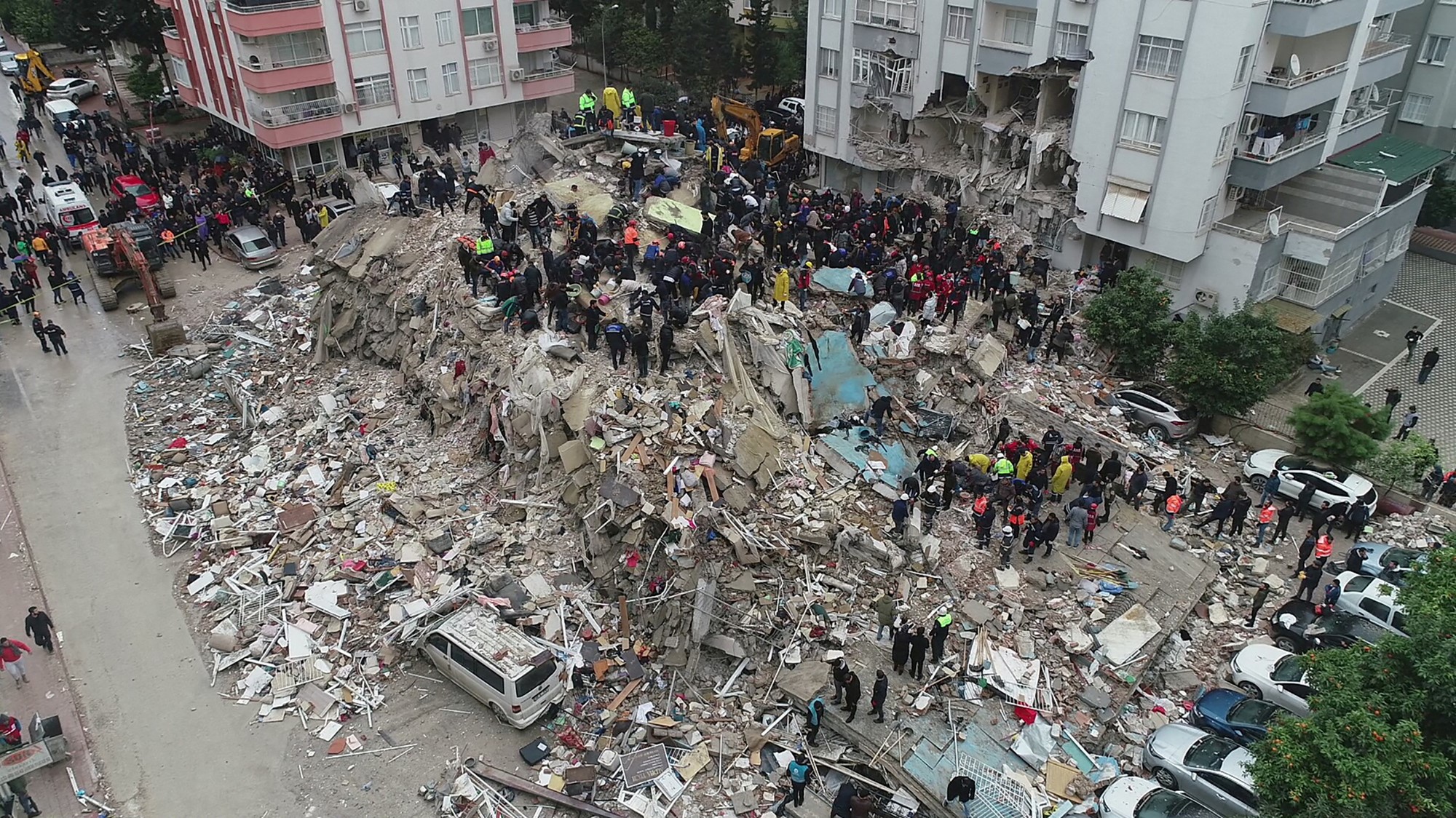 People search a collapsed building following an earthquake in Azmarin town, Idlib province, northern Syria