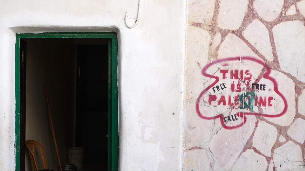 A sign on a wall that says 'This is Palestine'