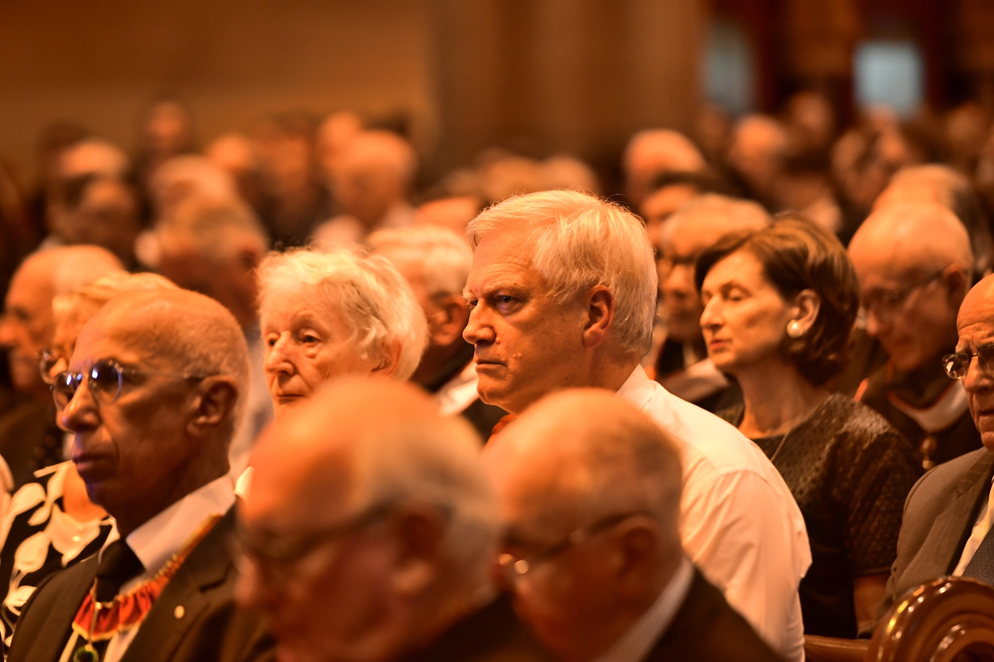 Andrew Bolt sits in a crowd of people in church.