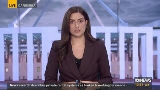 A woman in a brown blazer and long brown hair gives a live TV cross from a studio in Canberra.