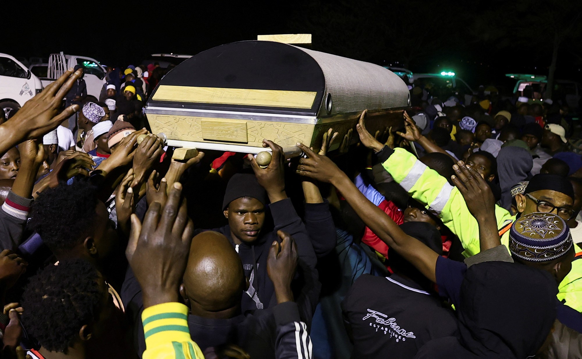 People hold up a coffin. 