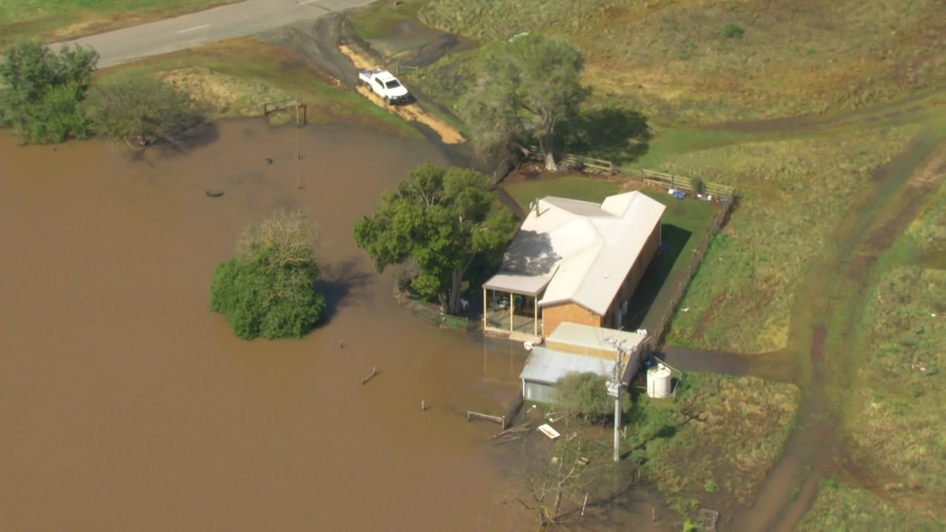 Aerial shot of house surrounded by floodwaters.
