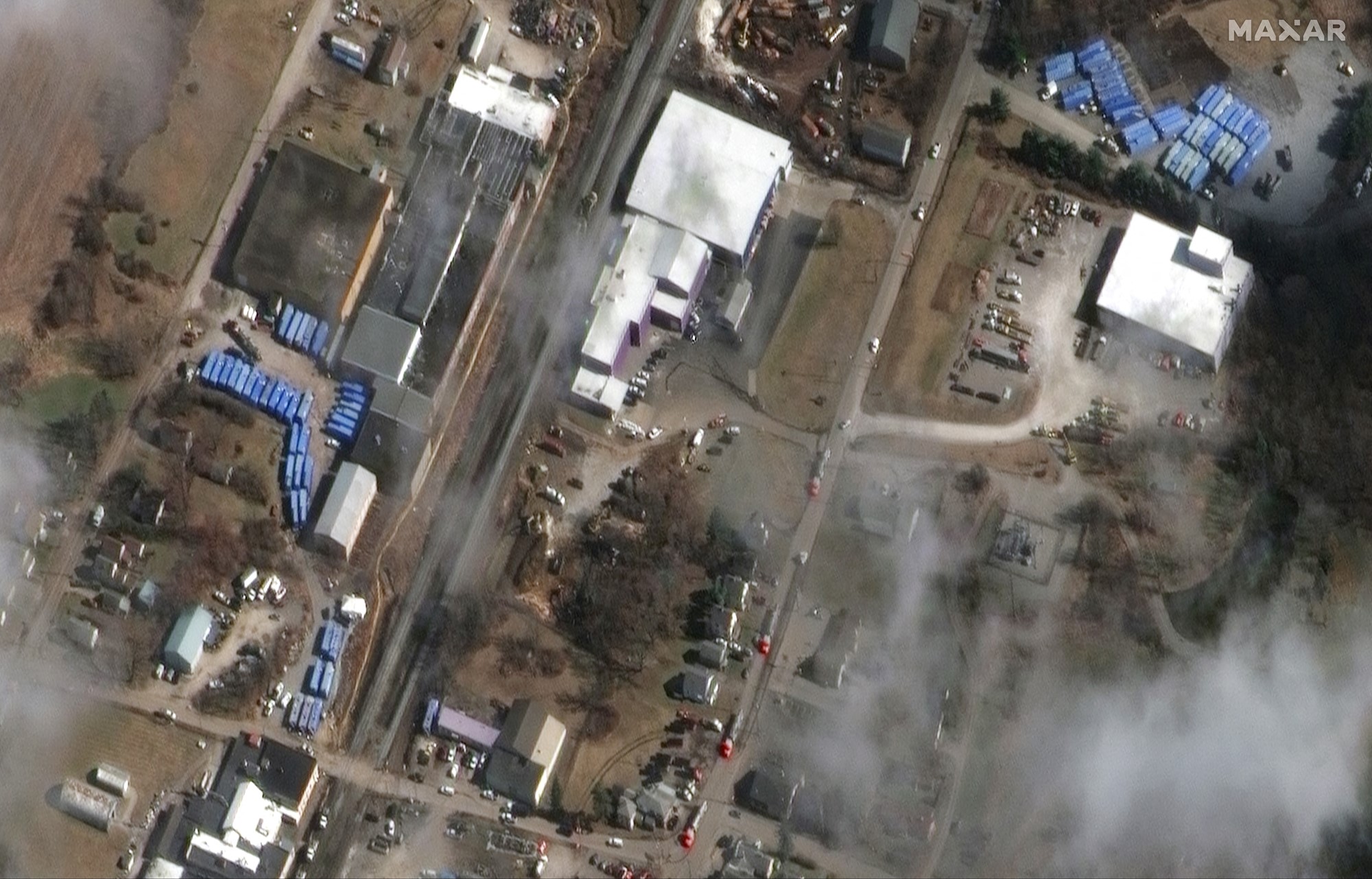 A satellite image of a train yard with blue shipping containers. 