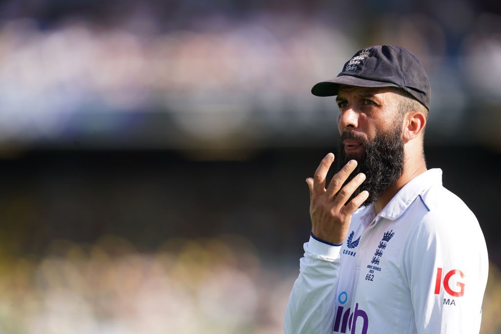 Moeen Ali blows on his sore finger.