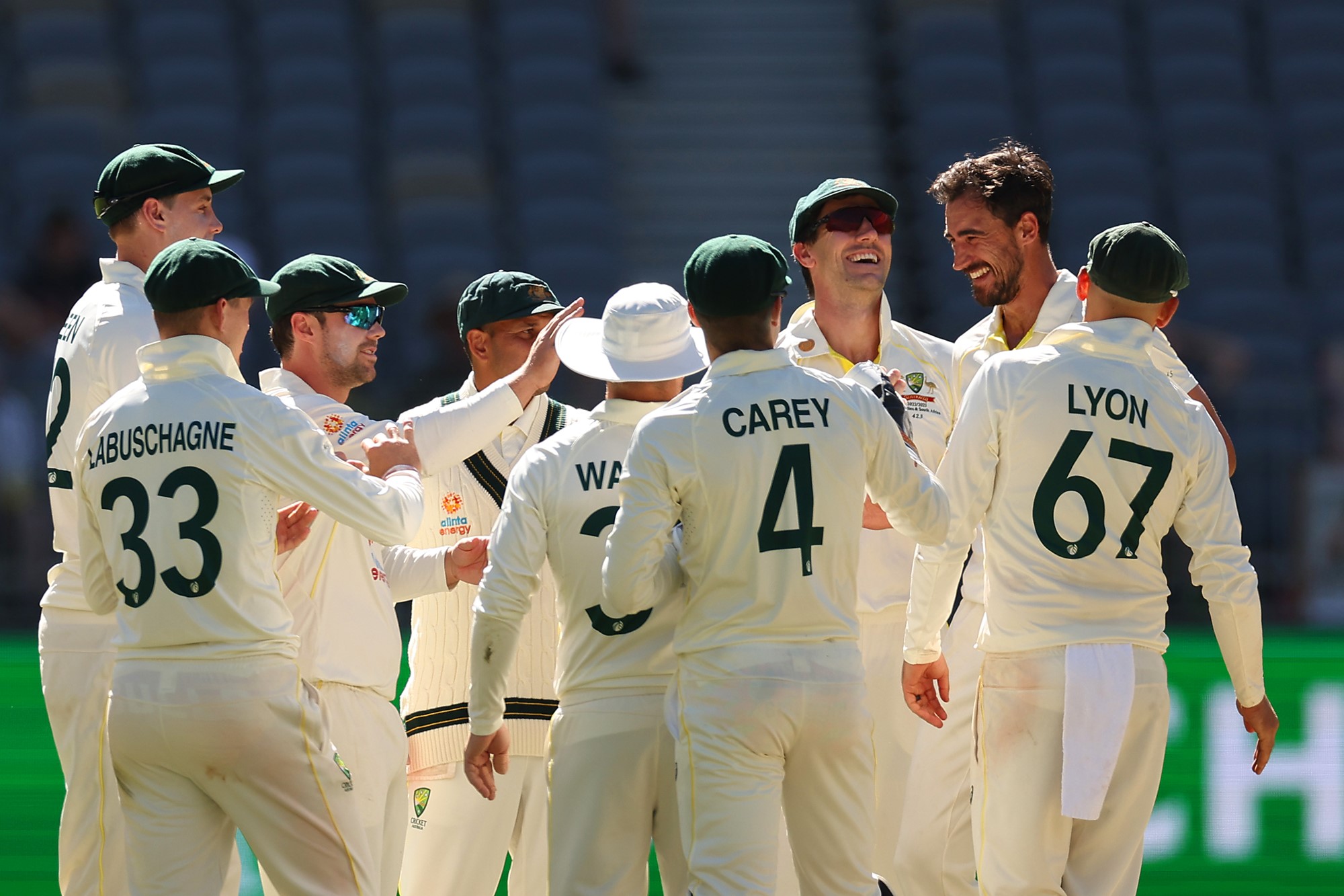 Australian Test cricket players gather around in celebration during a Test against West Indies in Perth.