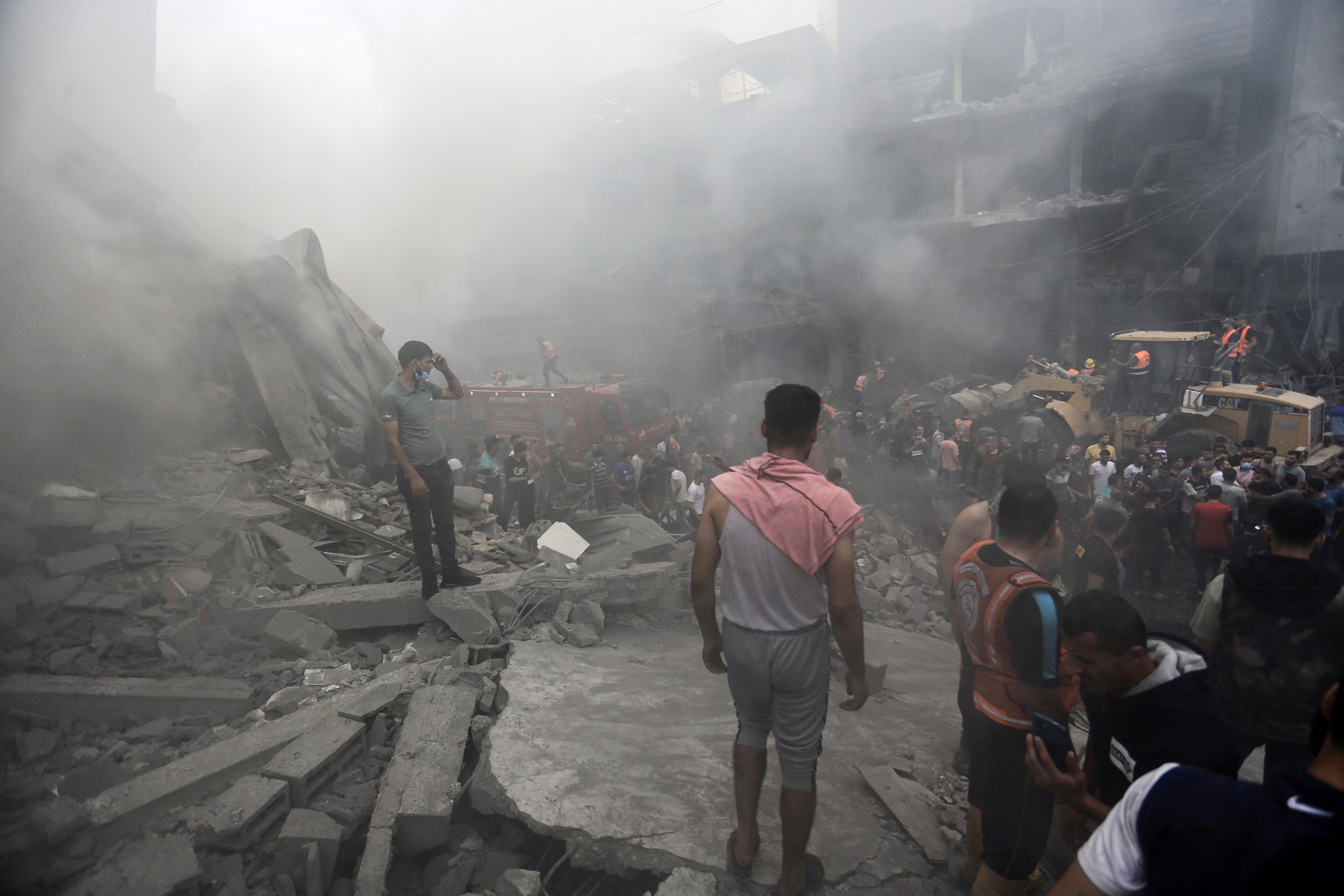 Men stand on the smoke filled street after a missile strike