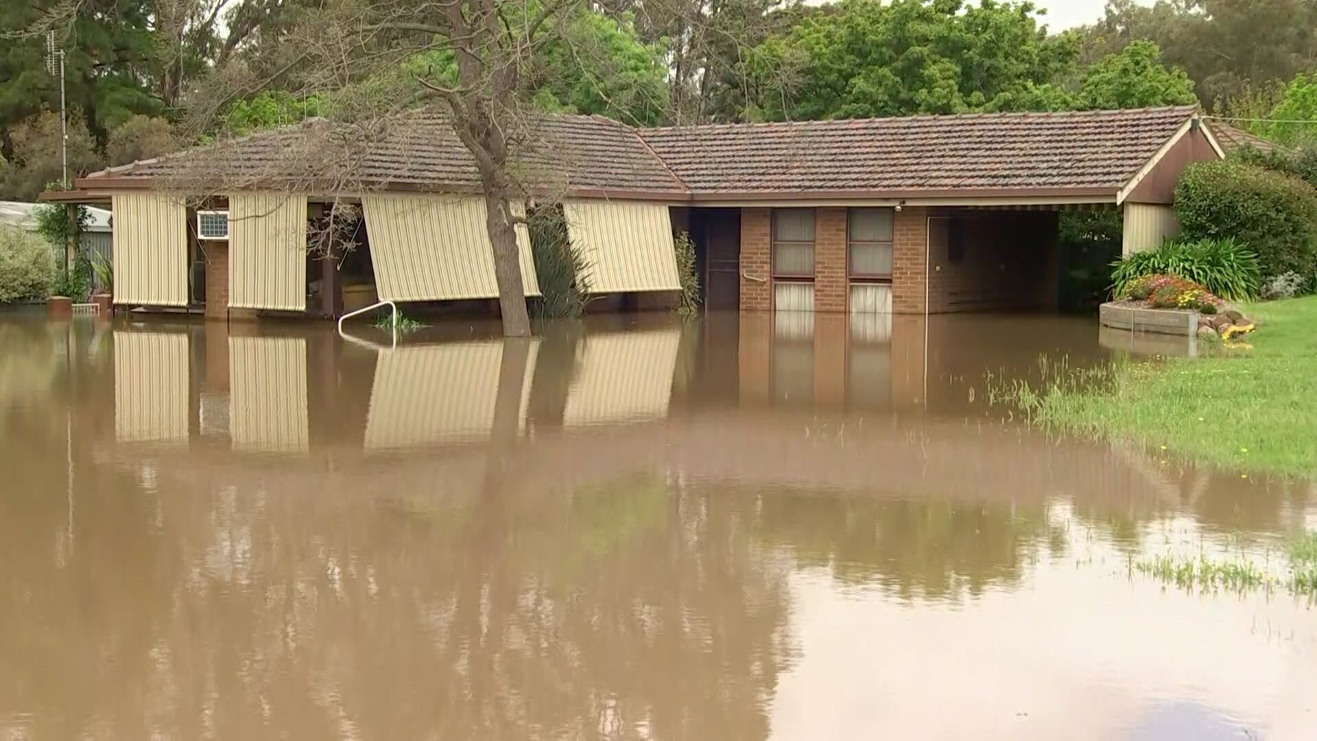 Picture shows a house surrounded by floodwaters.