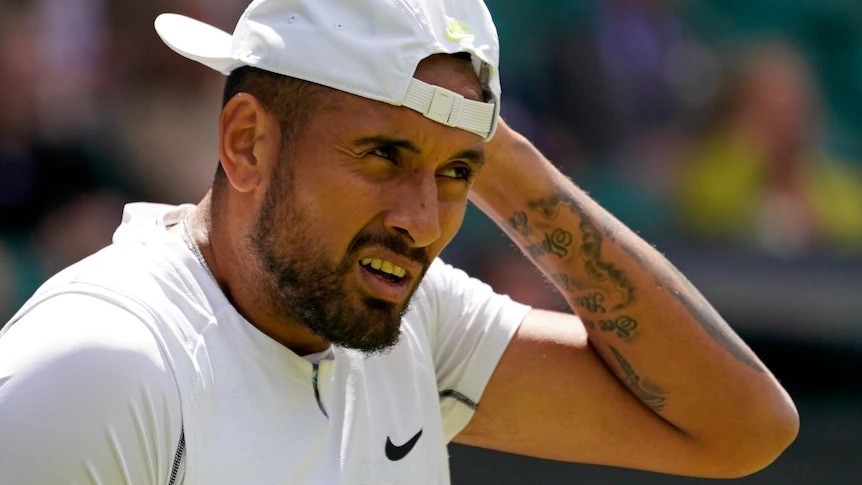 A man with tattoos wears a backwards white cap and white Nike shirt.
