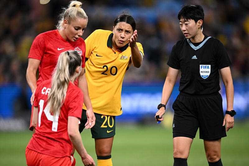 Sam Kerr of the Matildas gestures in a questioning motion to other players and referee during soccer match