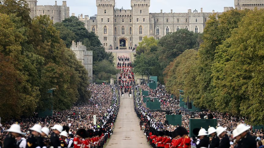 Crowds of people line the road to Windsor Castle as a funeral procession passes.